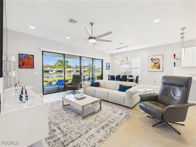 a living room with furniture ceiling fan and a large window