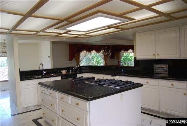 2570 Spinnaker Drive Reno, NV 89519 - Photo 4 of 9 a kitchen with stainless steel appliances a sink a stove and white cabinets