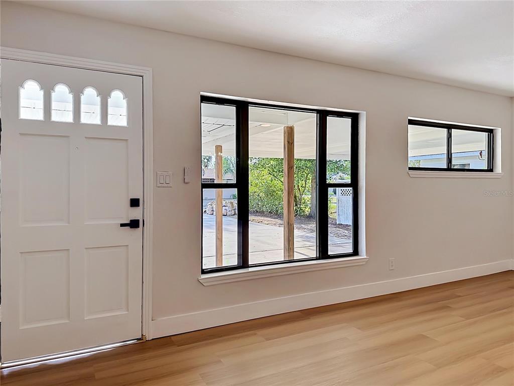 2105 Shaffer Place Orlando, FL 32806 - Photo 15 of 68 a view of an empty room with wooden floor and windows