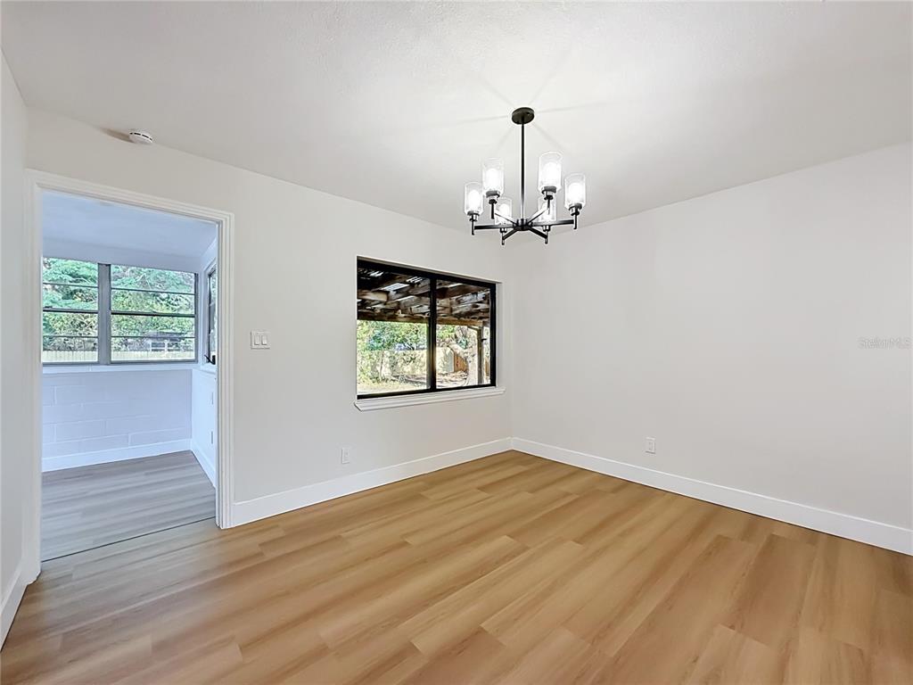 2105 Shaffer Place Orlando, FL 32806 - Photo 26 of 68 an empty room with wooden floor chandelier and windows