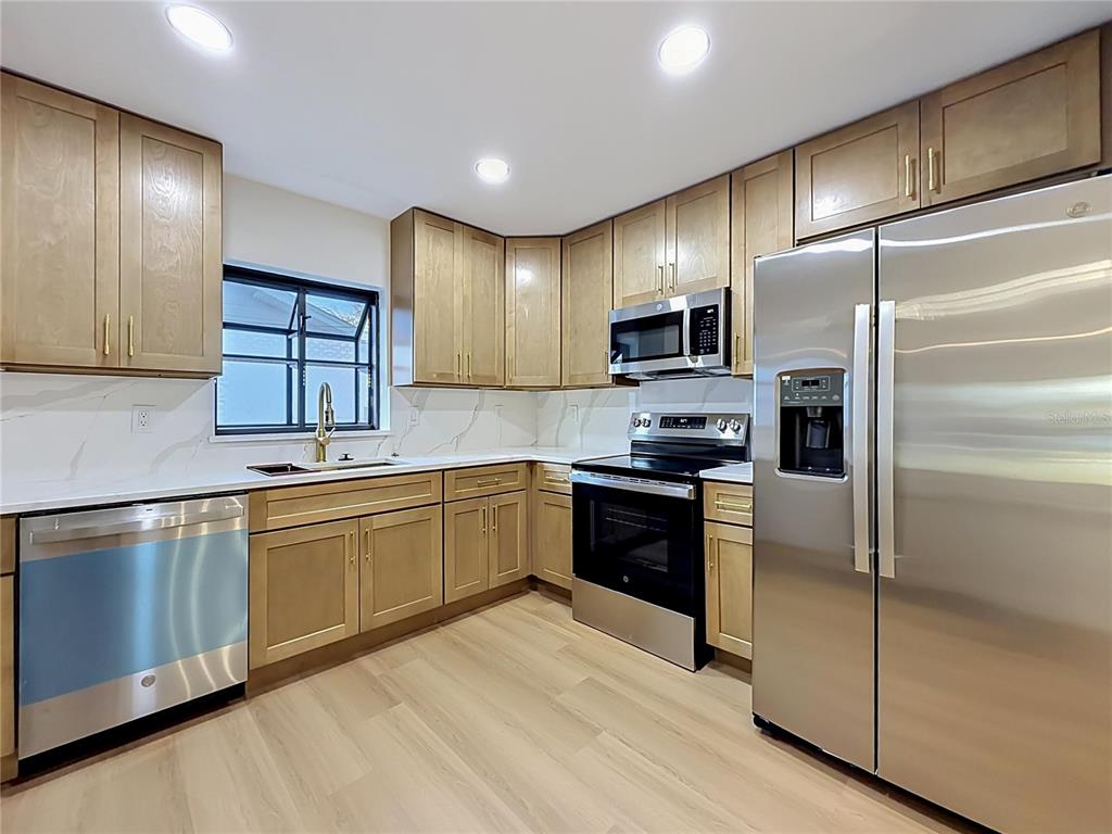2105 Shaffer Place Orlando, FL 32806 - Photo 28 of 68 a kitchen with granite countertop stainless steel appliances and wooden cabinets