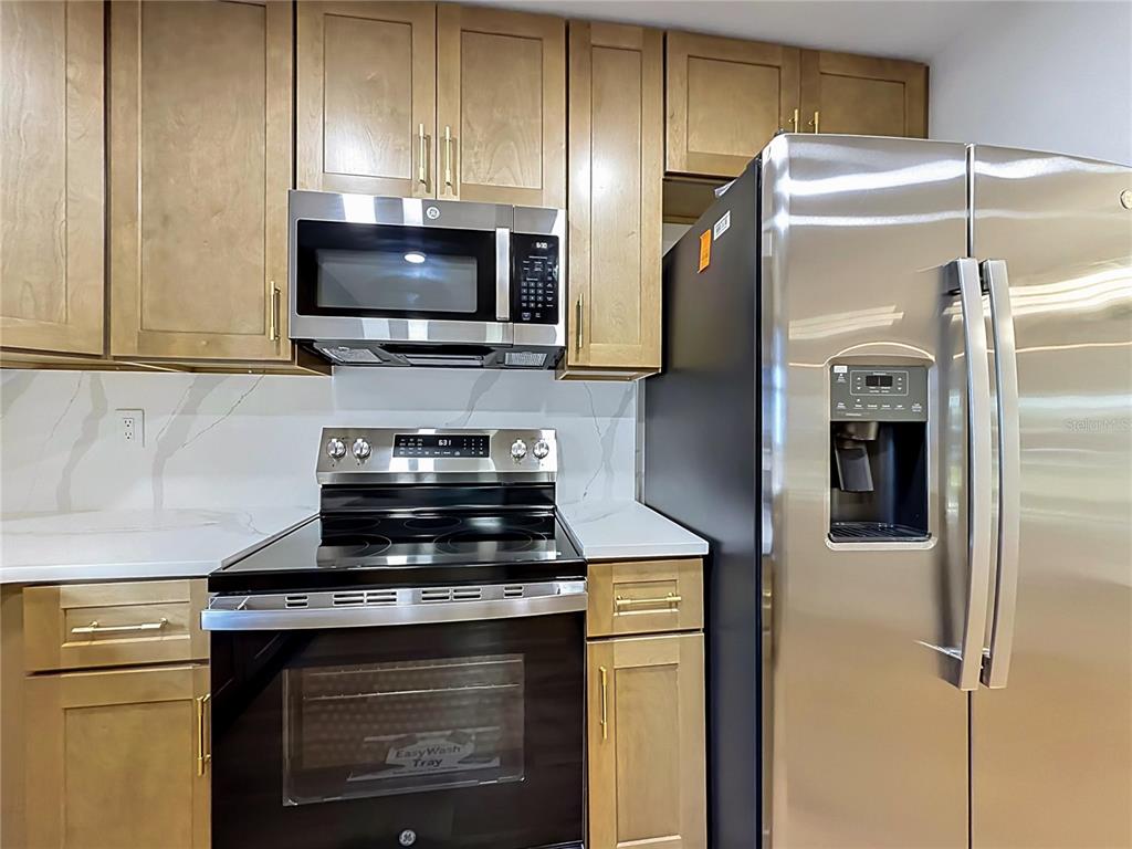 2105 Shaffer Place Orlando, FL 32806 - Photo 36 of 68 a kitchen with a stove and a microwave