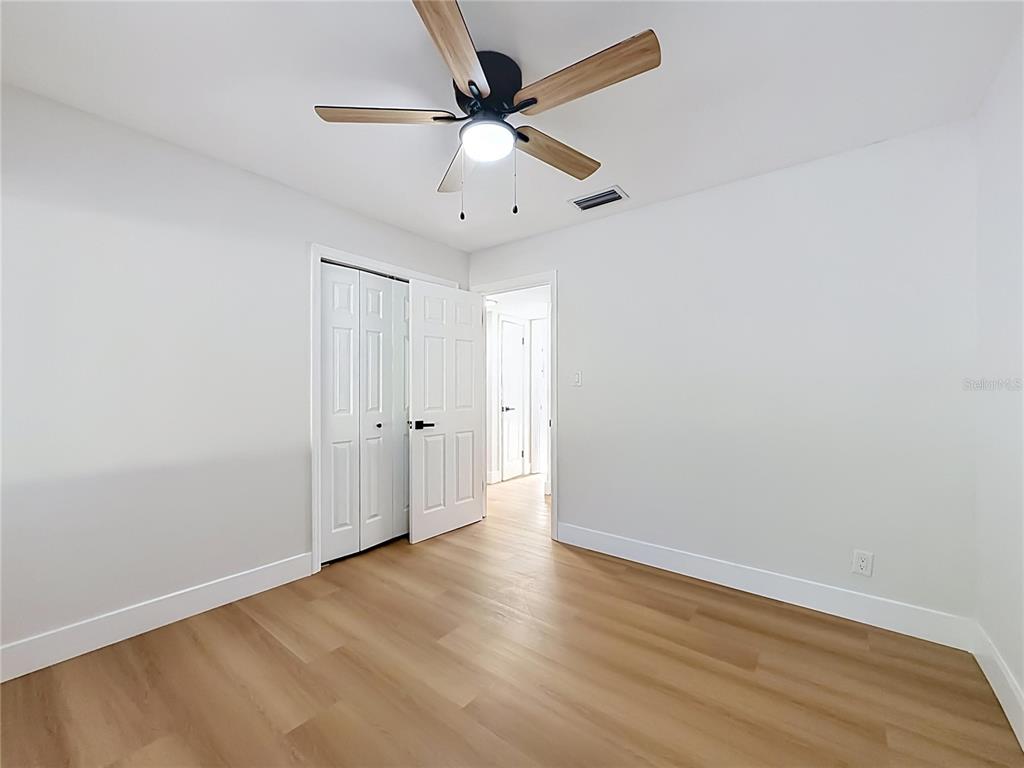 2105 Shaffer Place Orlando, FL 32806 - Photo 40 of 68 an empty room with wooden floor ceiling fan and windows