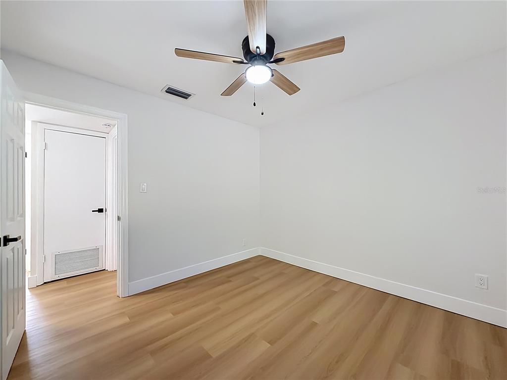 2105 Shaffer Place Orlando, FL 32806 - Photo 41 of 68 a view of a room with wooden floor and a ceiling fan