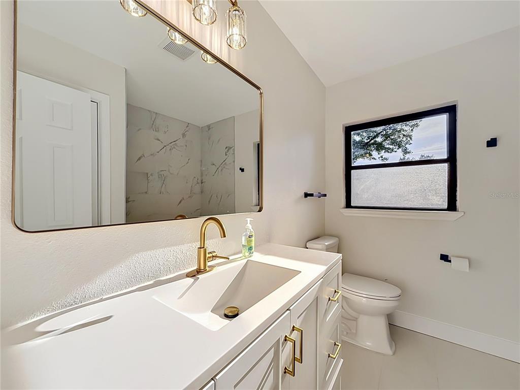 2105 Shaffer Place Orlando, FL 32806 - Photo 42 of 68 a bathroom with a sink a toilet and mirror