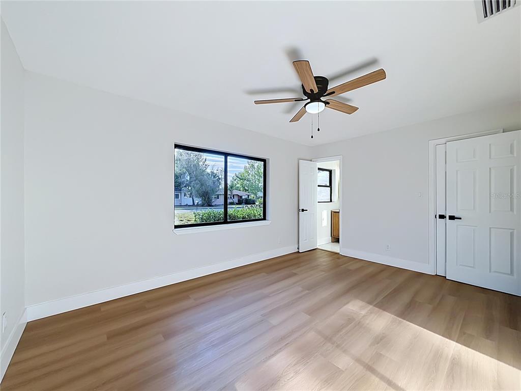 2105 Shaffer Place Orlando, FL 32806 - Photo 50 of 68 an empty room with wooden floor fan and windows
