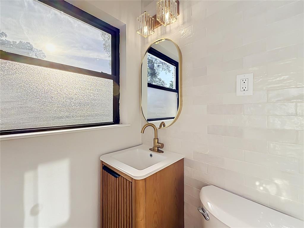 2105 Shaffer Place Orlando, FL 32806 - Photo 53 of 68 a bathroom with a toilet a sink and mirror