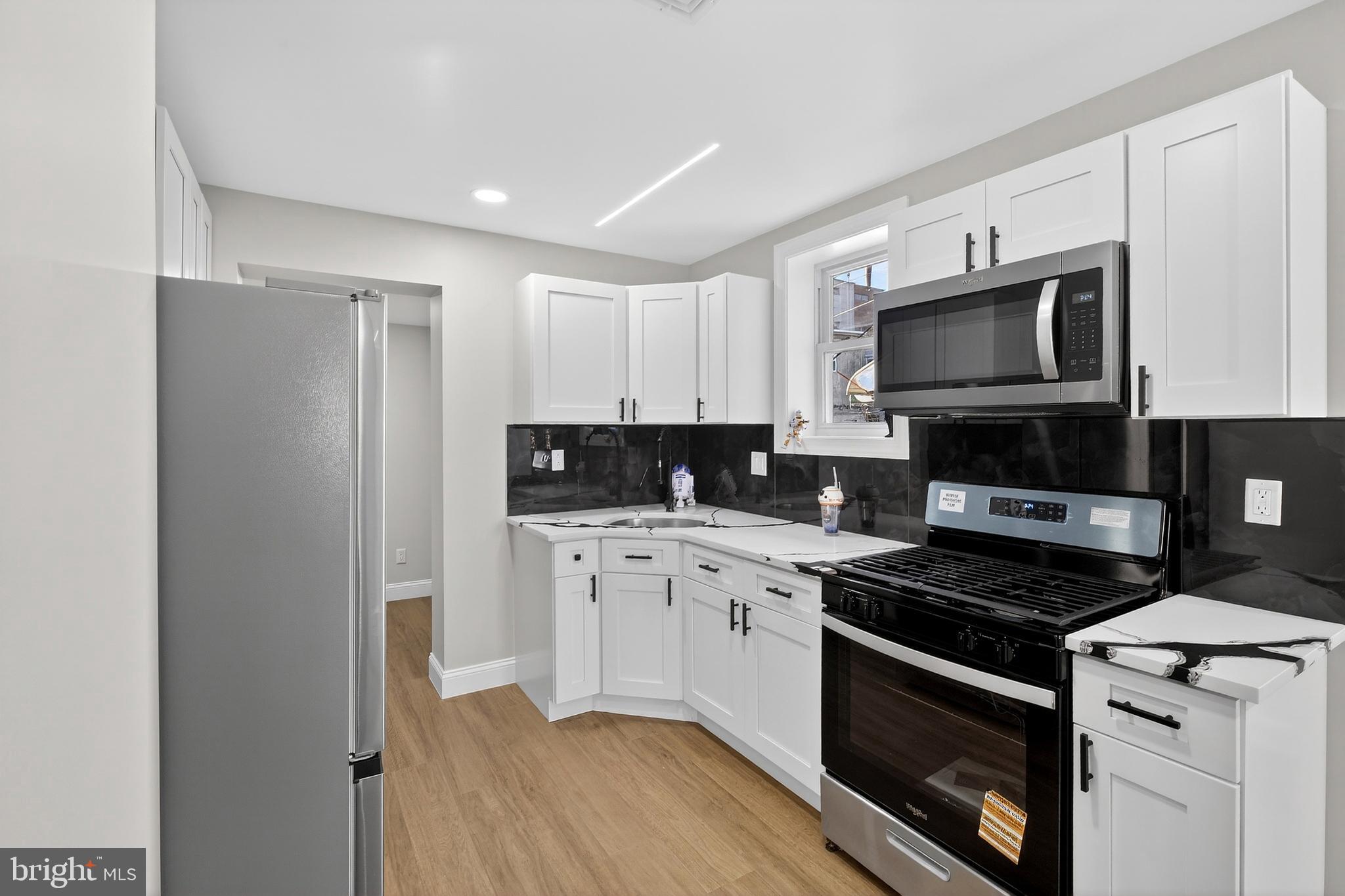 a kitchen with stainless steel appliances a stove a microwave and cabinets