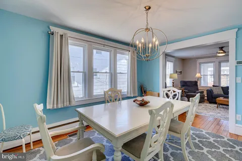 a dining room with furniture a rug a chandelier and wooden floor
