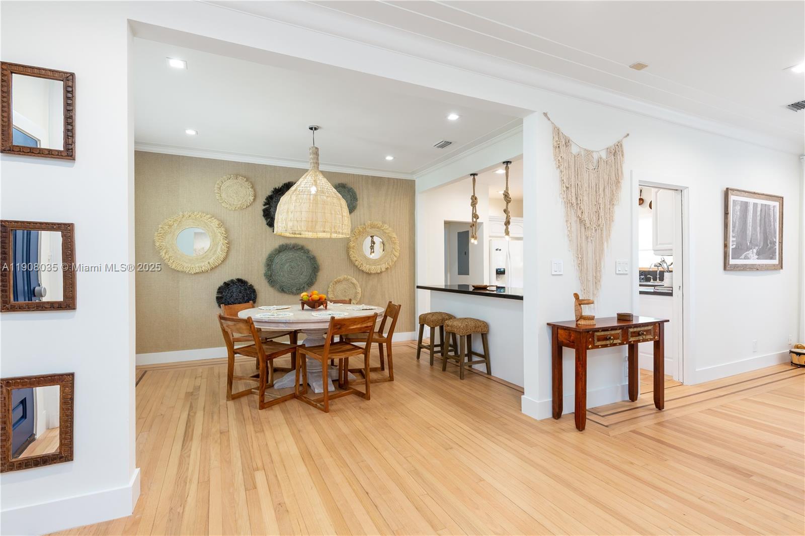 501 Southwest 19th Road Miami, FL 33129 - Photo 42 of 59 a dining room with wooden floor a chandelier a wooden table and chairs