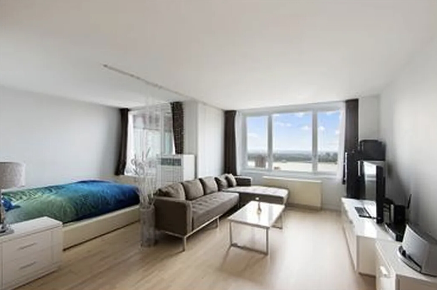 322 West 57th Street, Unit 48F Manhattan, NY 10019 - Photo 1 of 12 a living room with furniture and a large window