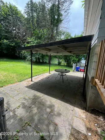 a view of a patio with table and chairs under an umbrella