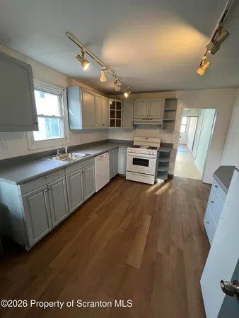 a open kitchen with cabinets a sink and appliances