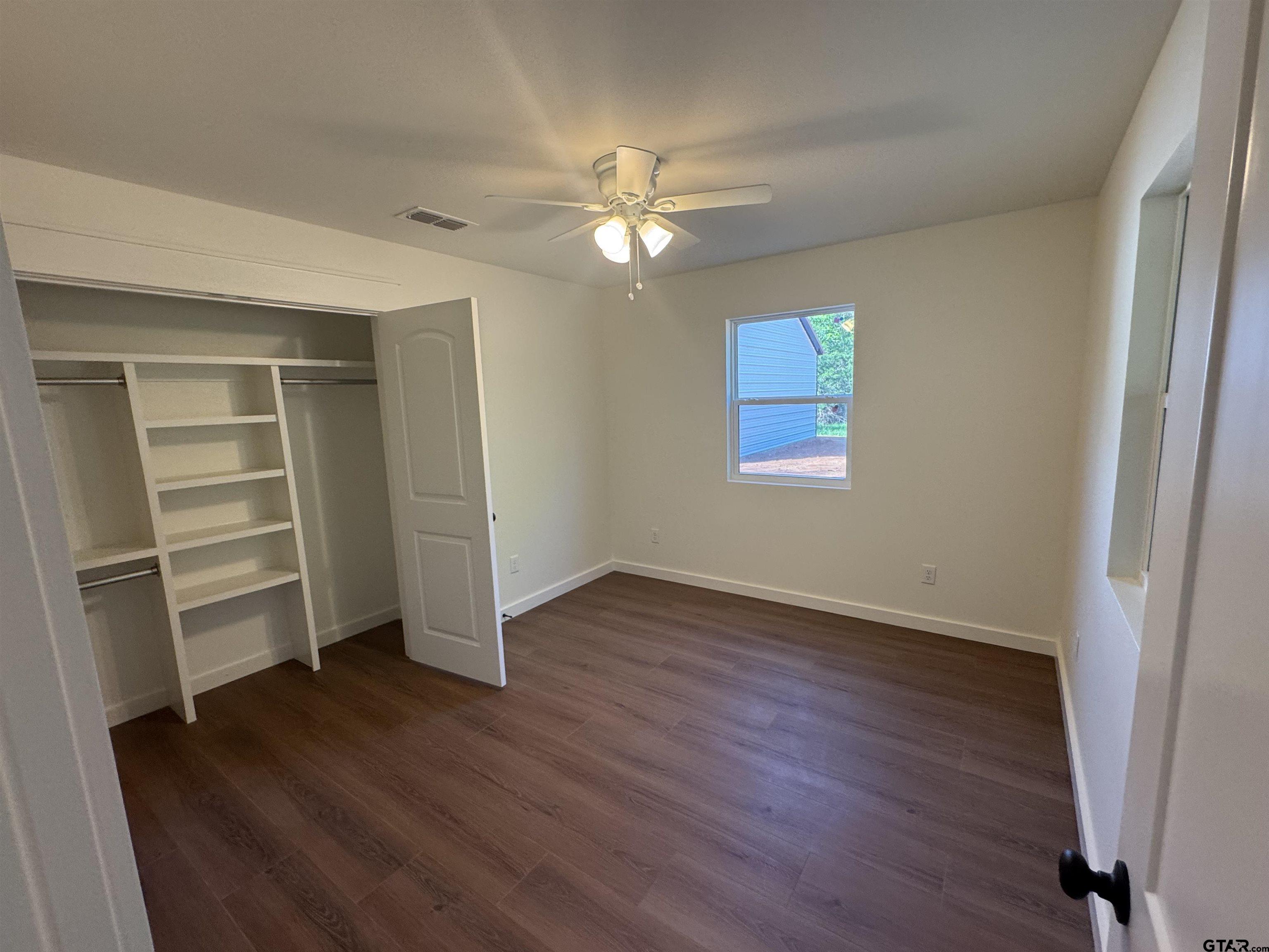 21070-c R 4147 C R 4147 Lindale, TX 75771 - Photo 11 of 23 an empty room with wooden floor closet fan and windows
