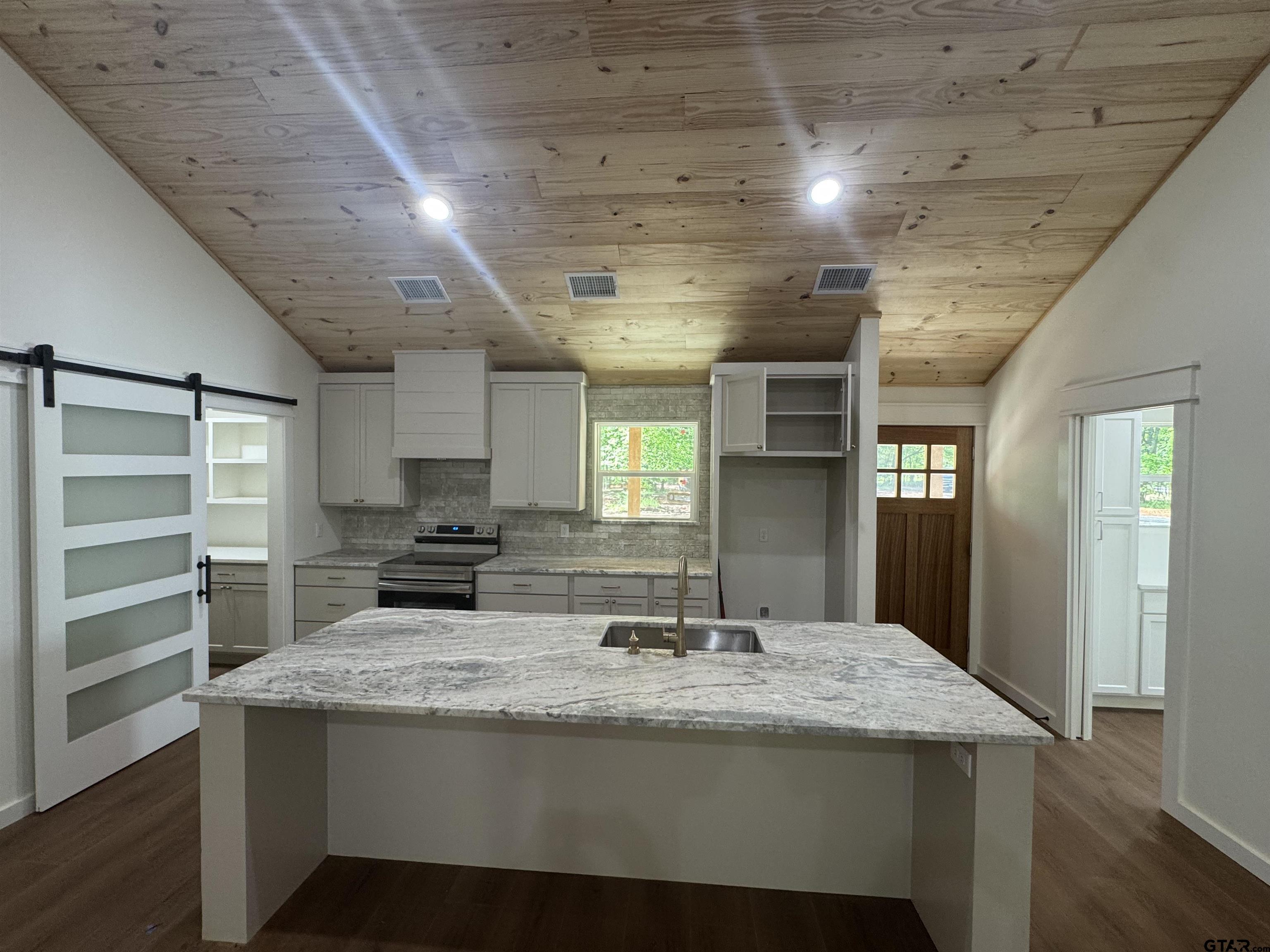 21070-c R 4147 C R 4147 Lindale, TX 75771 - Photo 4 of 23 a kitchen with kitchen island stainless steel appliances a sink stove and cabinets