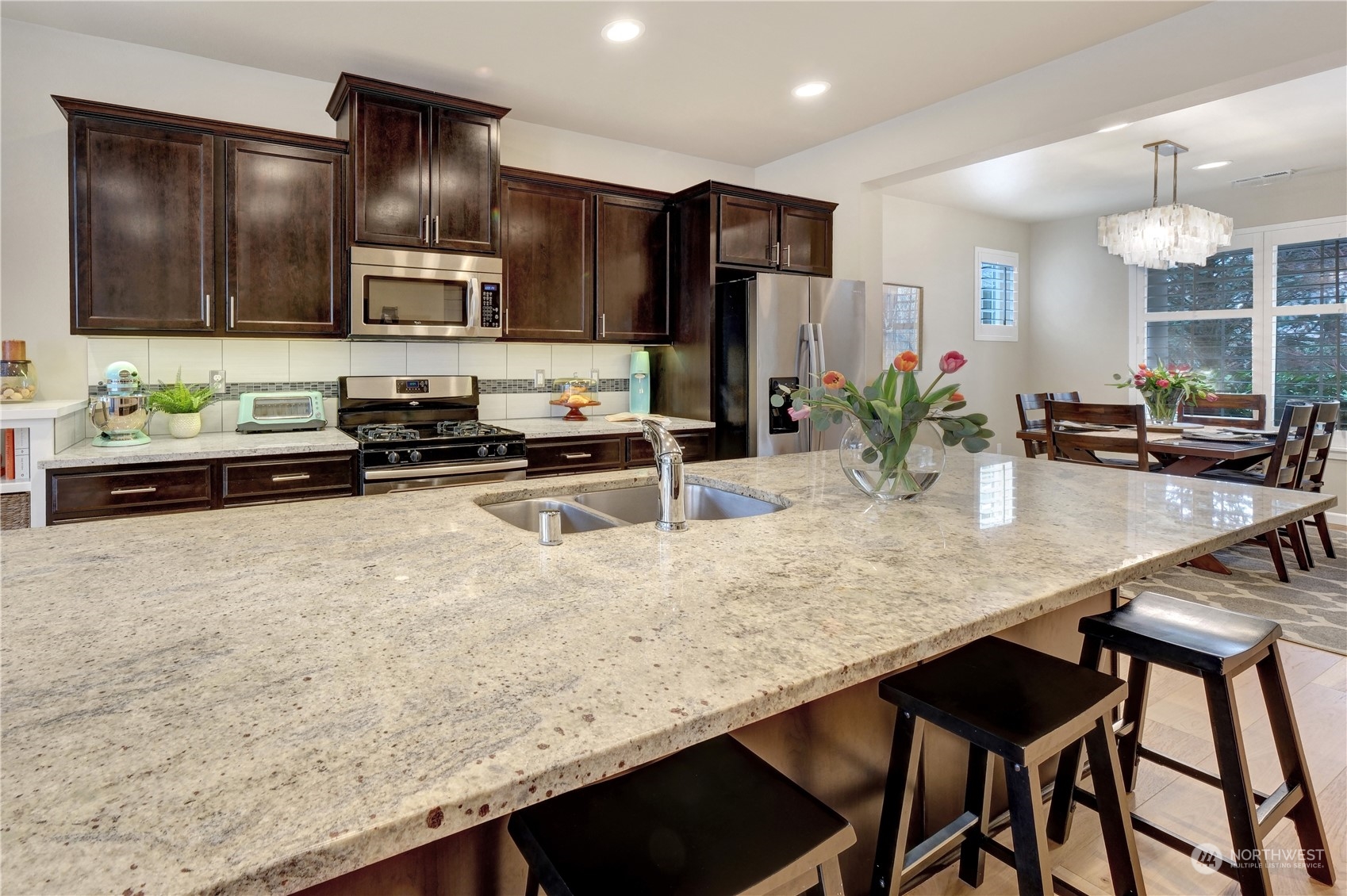 21907 37th Drive Southeast, Unit 30 Bothell, WA 98021 - Photo 12 of 27 a kitchen with granite countertop a table chairs stove and cabinets