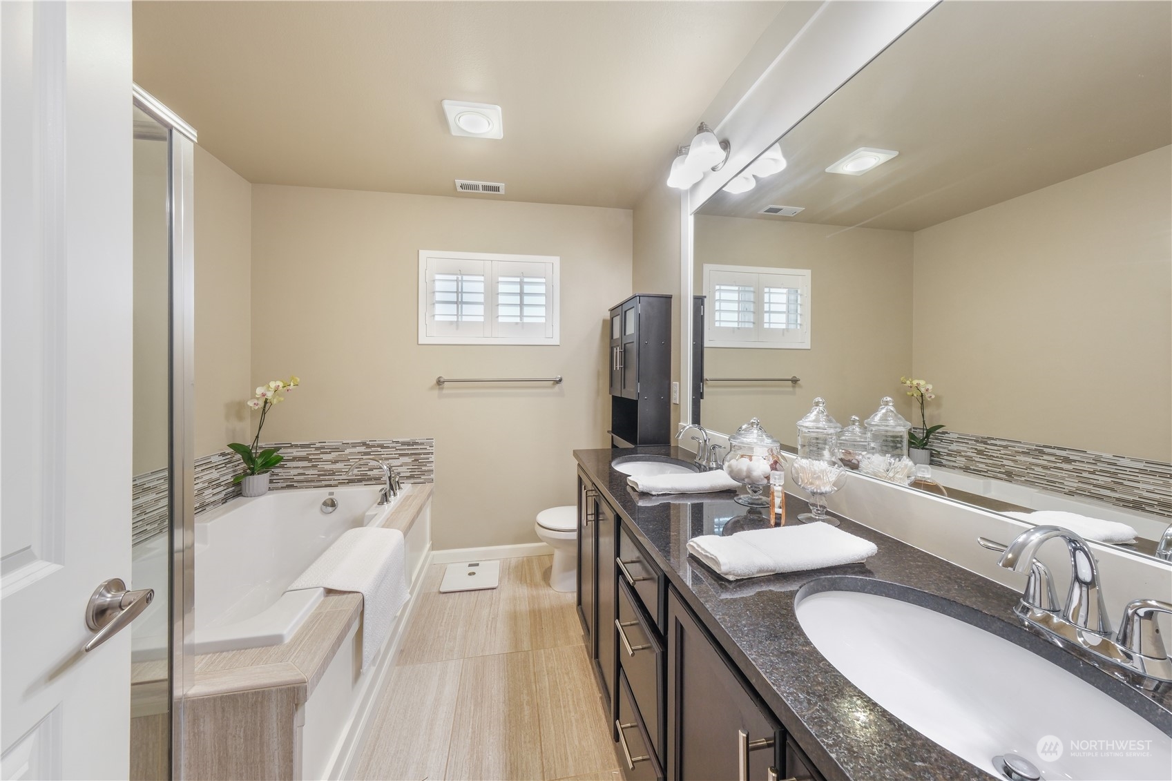 21907 37th Drive Southeast, Unit 30 Bothell, WA 98021 - Photo 20 of 27 a bathroom with a granite countertop sink a mirror and a bathtub