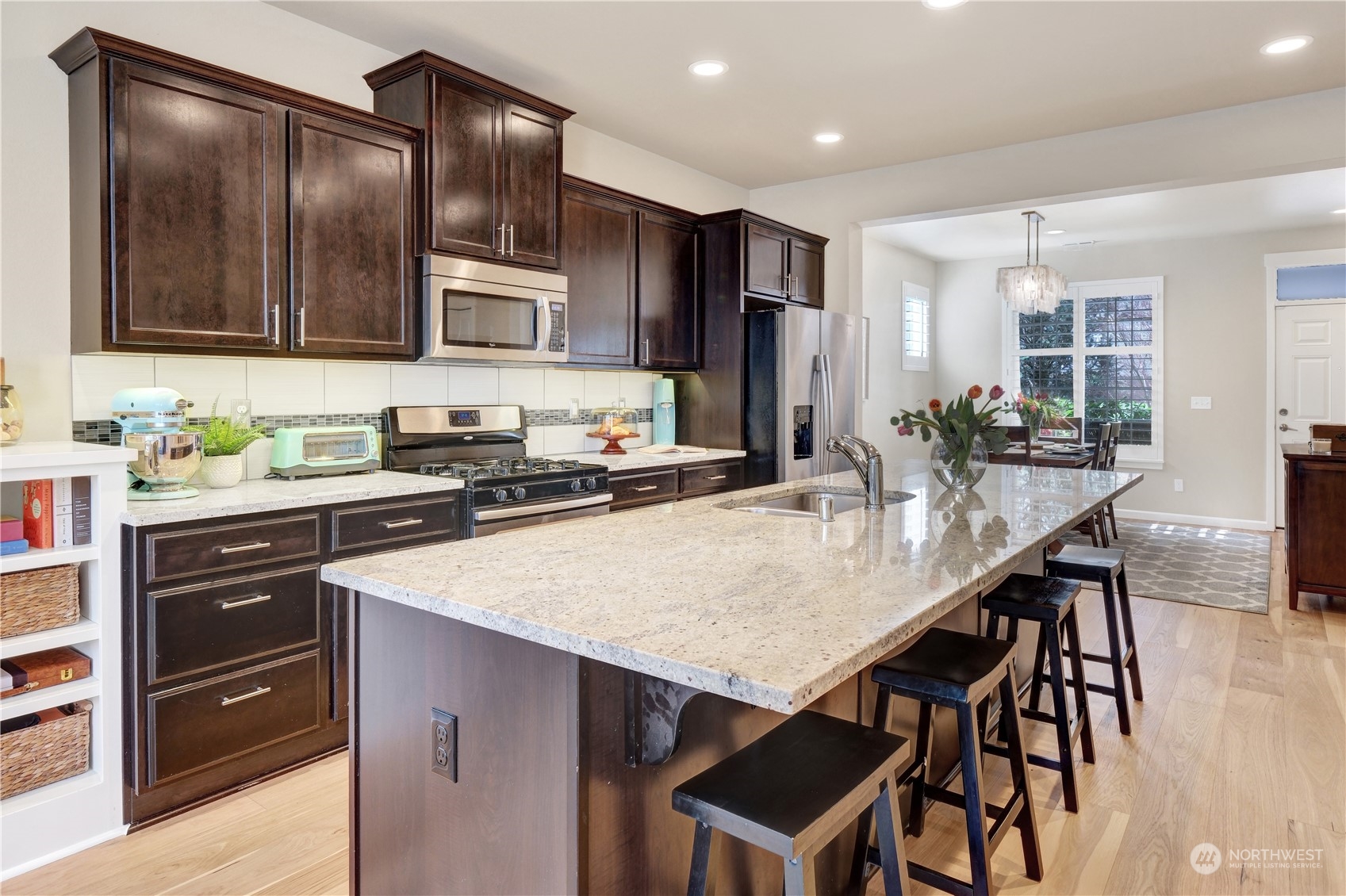 21907 37th Drive Southeast, Unit 30 Bothell, WA 98021 - Photo 7 of 27 a kitchen with stainless steel appliances wooden cabinets a center island and chairs