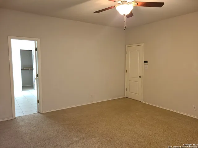 an empty room with a chandelier fan