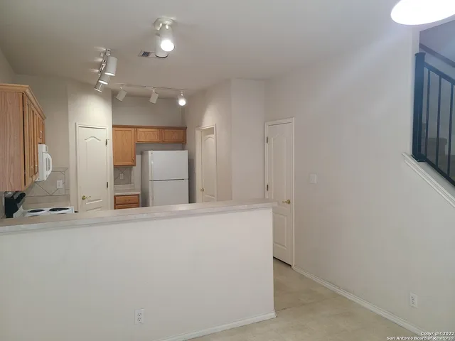 a view of a kitchen with a sink and a refrigerator