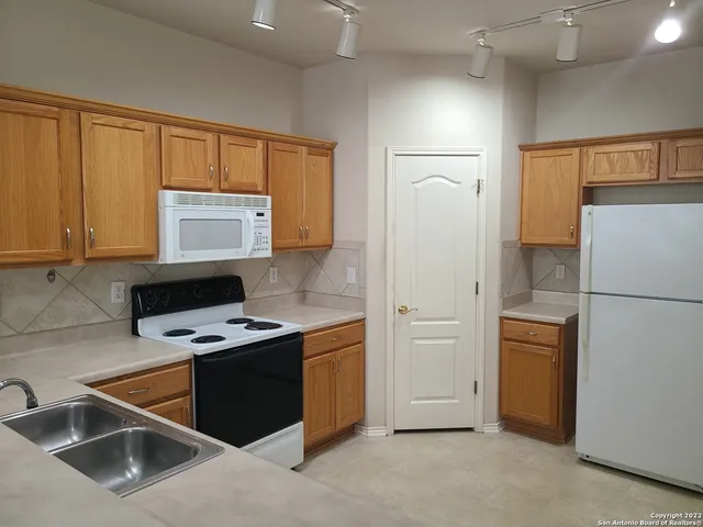 a kitchen with stainless steel appliances a refrigerator sink and cabinets