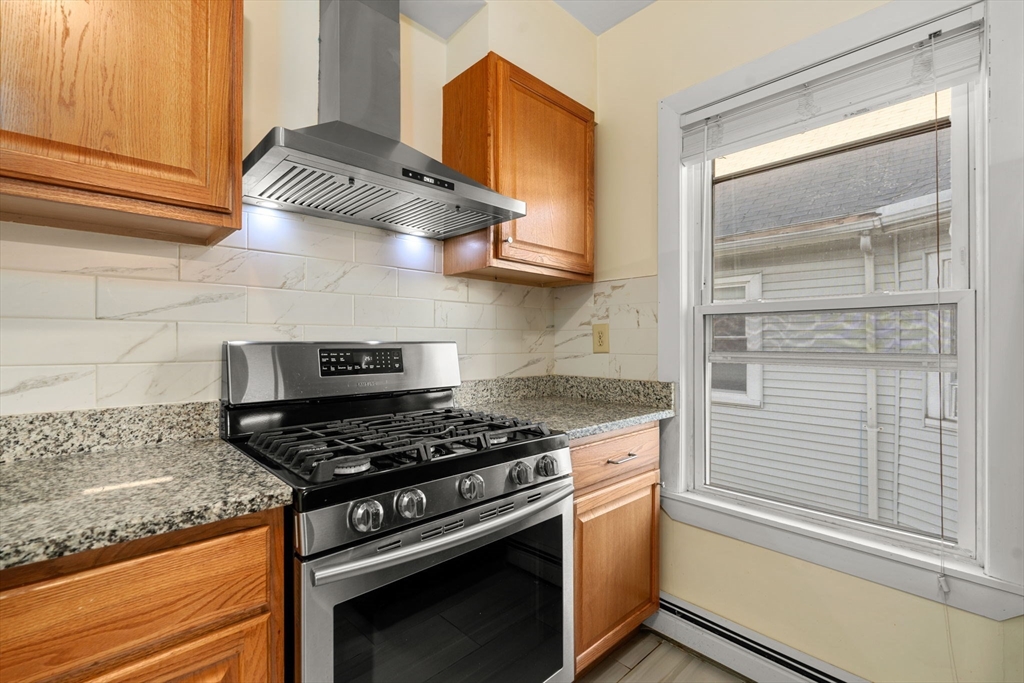 3266 Washington Street, Unit 3F Boston, MA 02130 - Photo 2 of 20 a kitchen with granite countertop stainless steel appliances and cabinets