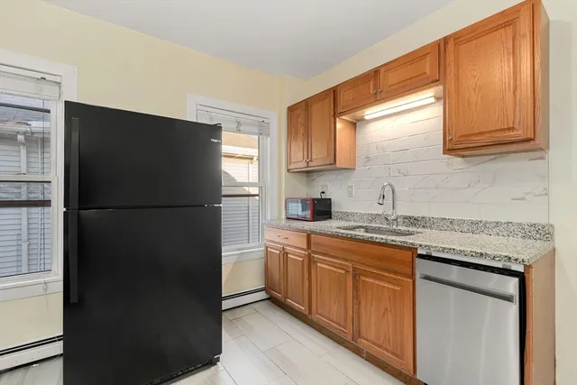 a kitchen with a refrigerator sink and cabinets