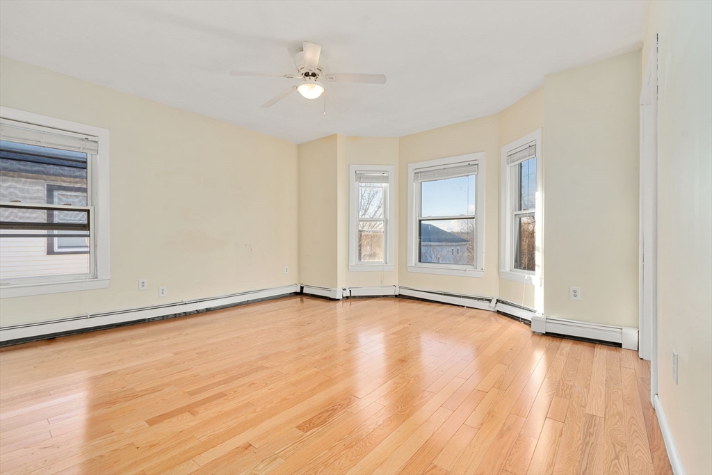 3266 Washington Street, Unit 3F Boston, MA 02130 - Photo 5 of 20 a view of an empty room with wooden floor and a window