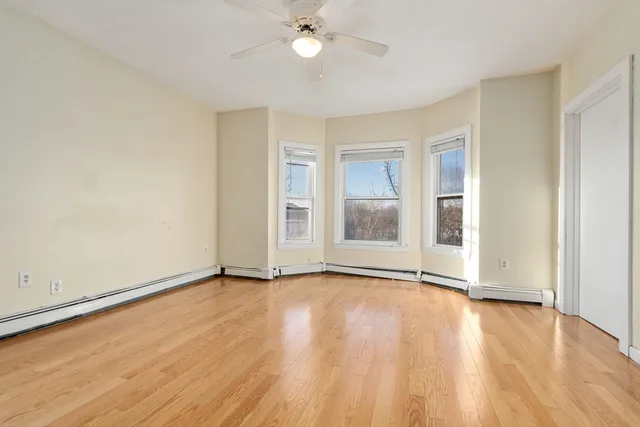 a view of an empty room with wooden floor
