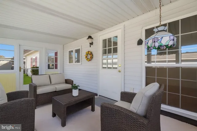 an empty room with wooden floor chandelier fan and windows