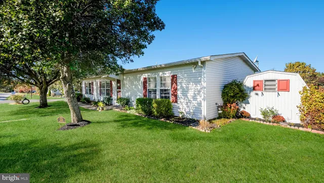 a front view of house with a garden and trees