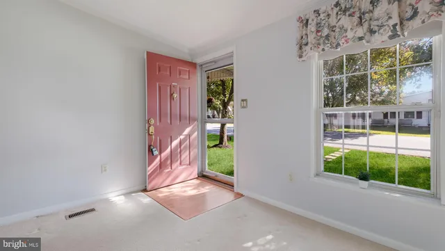 a view of a big room with windows and chandelier fan