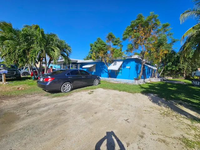 a car parked in front of a house and a yard