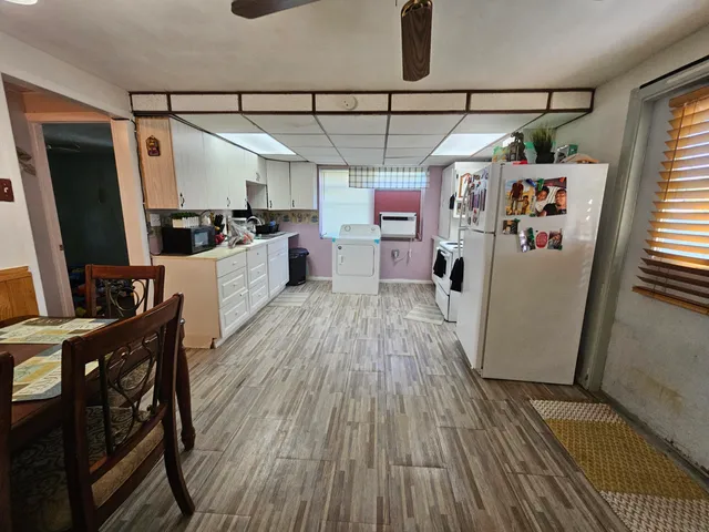 a kitchen with sink a refrigerator and wooden floor