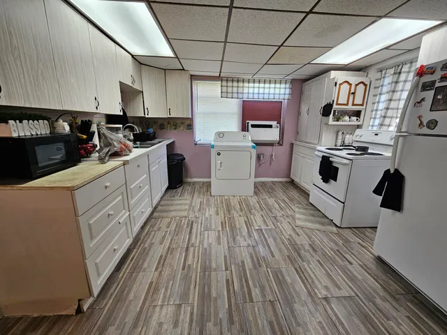 a kitchen with cabinets wooden floor and stainless steel appliances