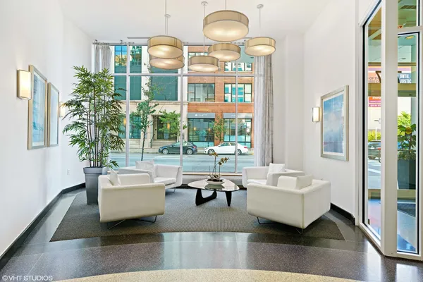 a living room with furniture chandelier and a large mirror
