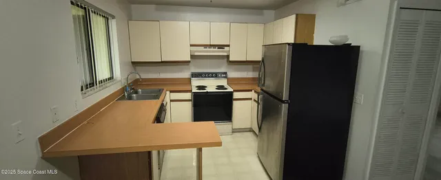 a kitchen with a refrigerator and a stove top oven