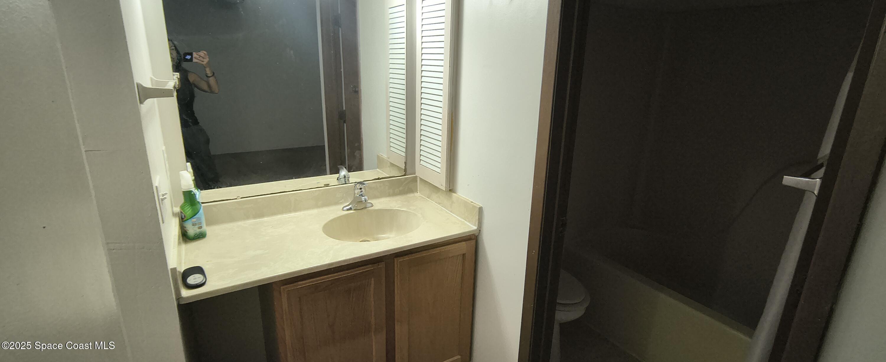 7801 Maplewood Drive, Unit 911 Melbourne, FL 32904 - Photo 9 of 16 a bathroom with a sink and a mirror