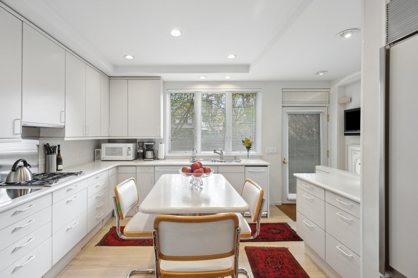 228 Sheridan Road Winnetka, IL 60093 - Photo 6 of 32 a kitchen with a stove a sink a refrigerator dining table and chairs