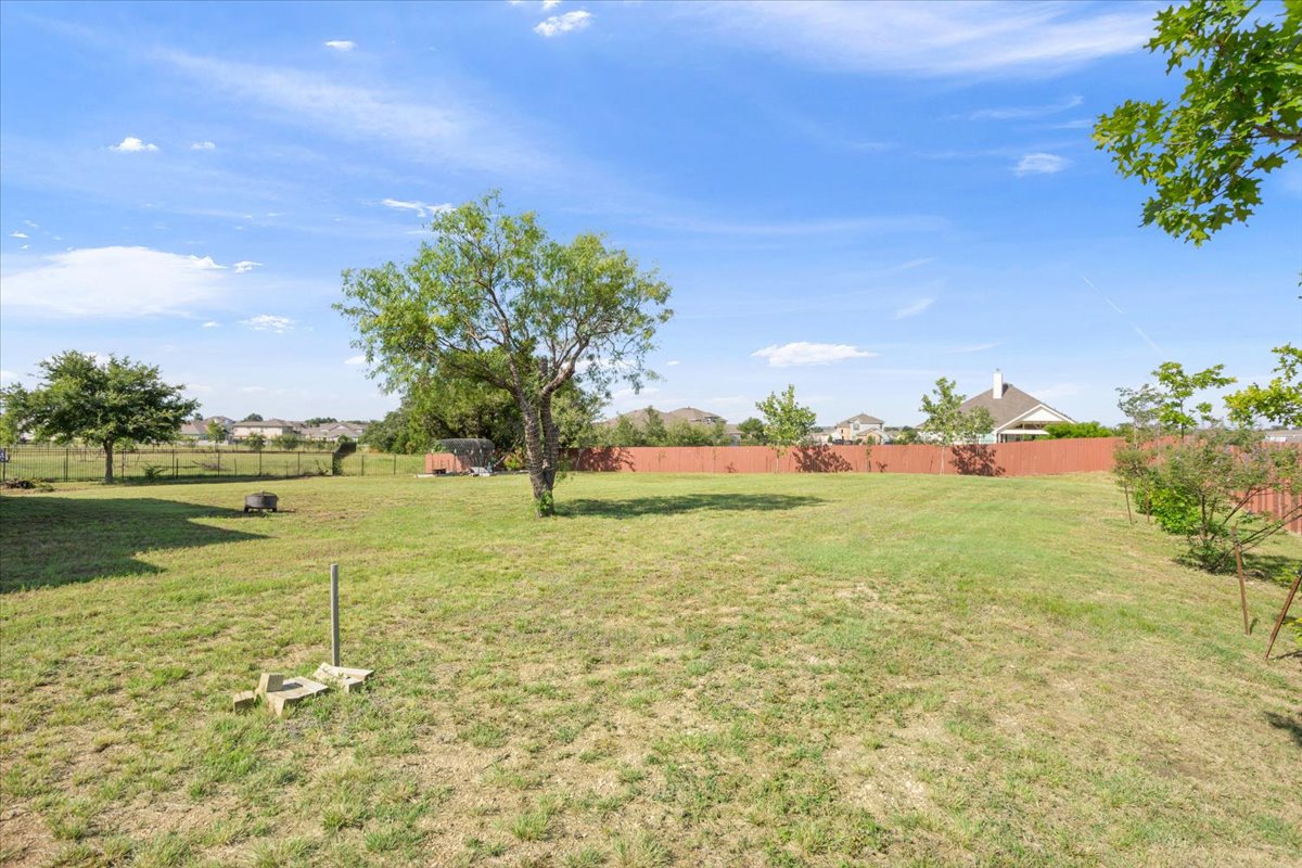 3625 Garrano Bend Leander, TX 78641 - Photo 32 of 38 A spacious backyard with mature trees offers ample room for outdoor activities and future enhancements.