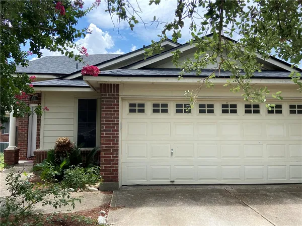 a front view of a house with a tree