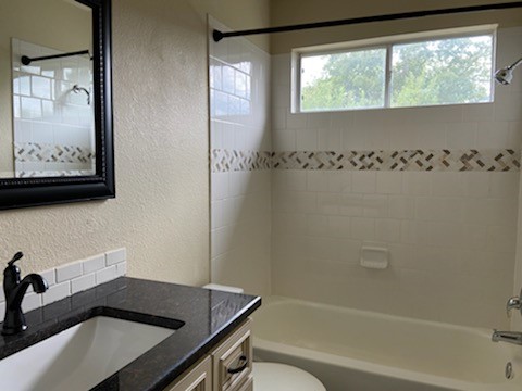 1257 Pine Portage Loop Leander, TX 78641 - Photo 25 of 32 Full bathroom featuring vanity, a textured wall, and bathing tub / shower combination