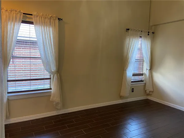 a view of a hallway with wooden floor and window