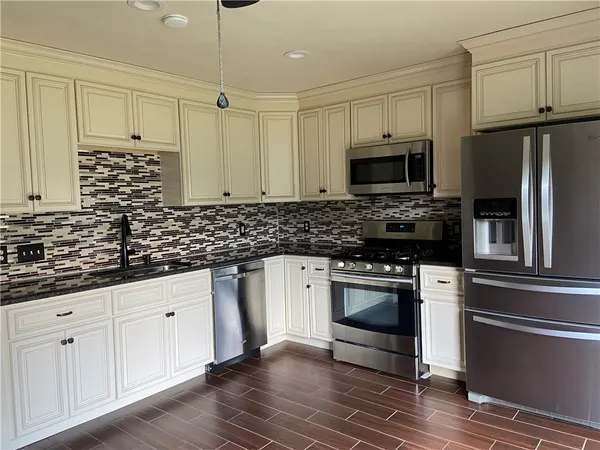 a kitchen with granite countertop white cabinets stainless steel appliances and sink