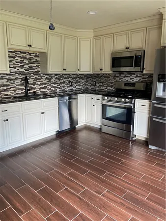 a kitchen with stainless steel appliances a stove a sink and a microwave