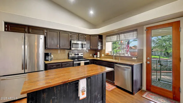 a kitchen with stainless steel appliances a stove refrigerator sink and cabinets