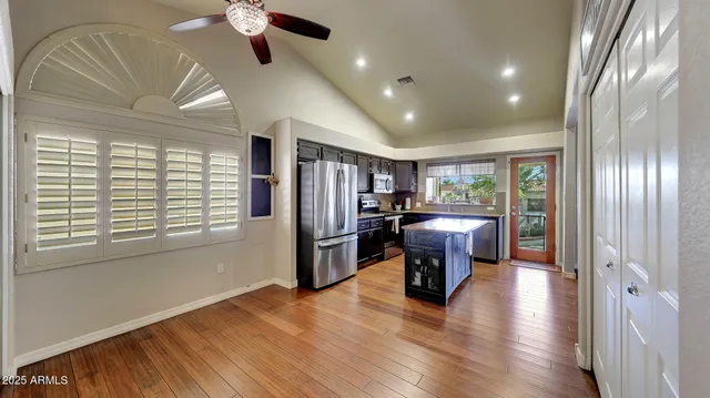 a view of a livingroom with furniture a ceiling fan and wooden floor