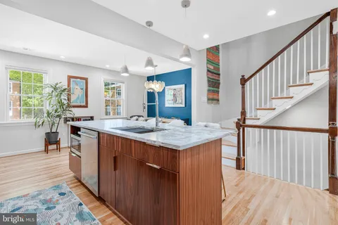 a kitchen with granite countertop a stove and a wooden floors