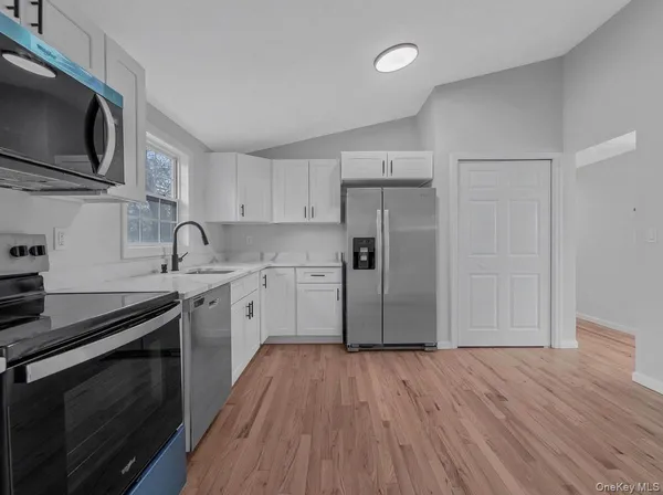 a kitchen with granite countertop a refrigerator and a stove top oven
