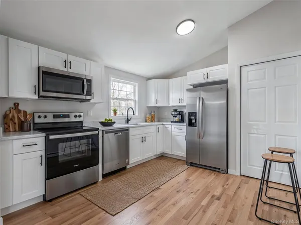 a kitchen with stainless steel appliances a stove a sink refrigerator and a microwave